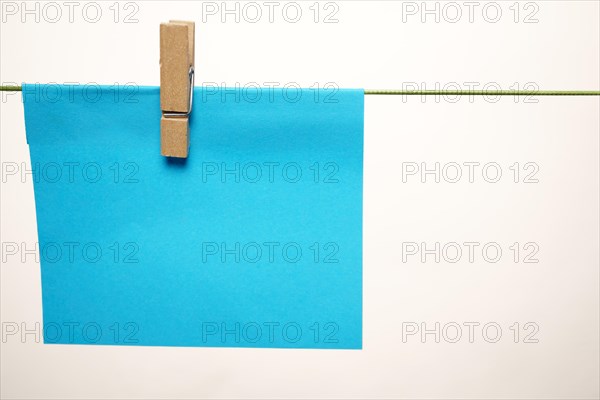 Sticky note hung with a clothespin on a clothesline with copy space and white background