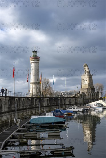 Lion pier with boats and Bavarian lion, in the back New Lindau lighthouse, Lindau harbour entrance, Lindau island, Lake Constance, Bavaria, Germany, Europe