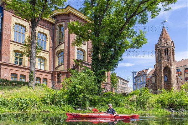 Paddler in a kayak on the Jakobskanal, behind Theodor-Fontane-School and Jakobskapelle, Brandenburg an der Havel, Brandenburg, Germany, Europe