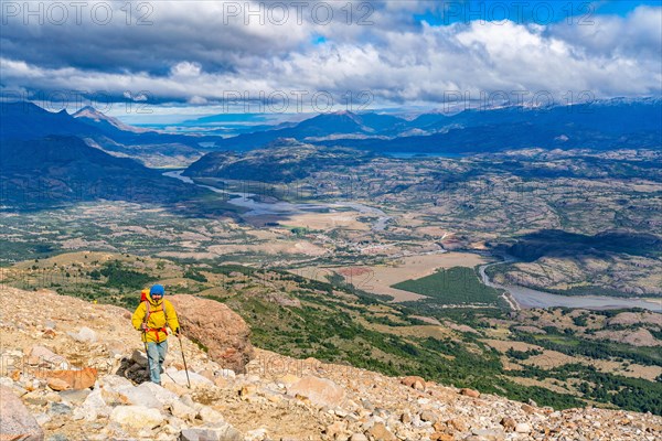 Hikers climbing to the lagoon on Cerro Castillo mountain, with the river valley of the Rio Ibanez in the background, Cerro Castillo National Park, Aysen, Patagonia, Chile, South America