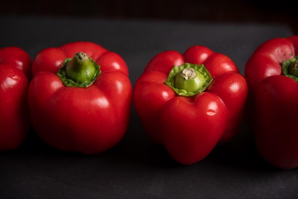 Red peppers in row on slate, fitness, cooking, vegetarian, vegan, vitamins, growing, garden, healthy, close up, kitchen