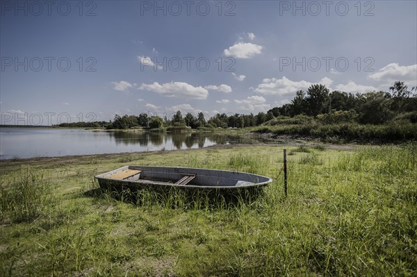 A boat lies at low water level at a dried up river bank, Waldhufen, Germany, Due to persistent heat and lack of precipitation many water bodies in Saxony are dried up or carry little water, Waldhufen, Germany, Europe