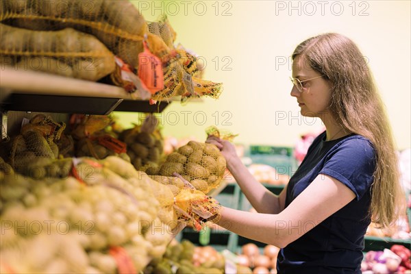 Younger woman shopping in supermarket, Radevormwald, Germany, Europe