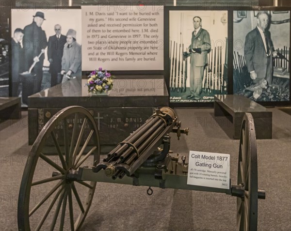 Claremore, Oklahoma, A Colt Model 1877 Gatling Gun displayed next to the tomb of J.M. Davis at the Davis Arms & Historical Museum. Davis, who collected thousands of firearms, said, I want to be buried with my guns. The museum boasts the worlds largest private firearms collection
