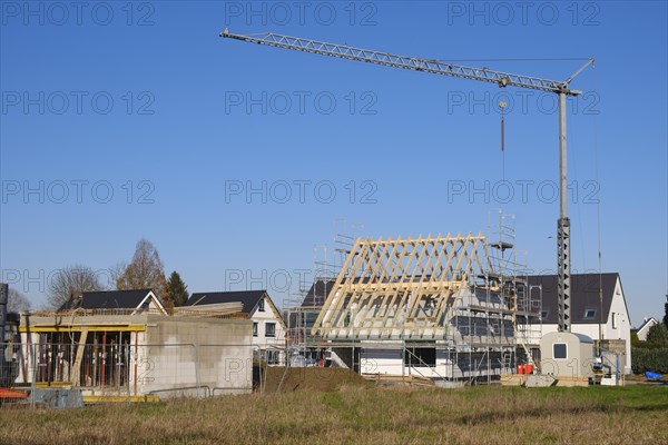 Residential house with scaffolding and open roof truss, construction site in a new housing estate, Kamen, North Rhine-Westphalia, Germany, Europe