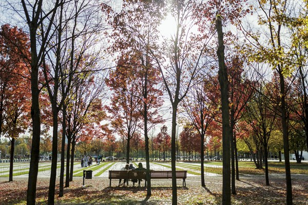 People sitting on a bench in autumn sunshine in the government district in Berlin, Berlin, Germany, Europe