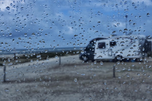 View through a window with raindrops on a camper van on a camper van pitch by the sea, Portbail, Normandy, France, Europe