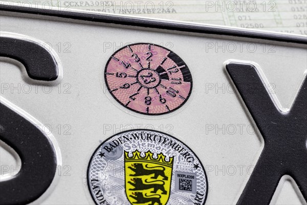 Official seal of the federal state of Baden-Wuerttemberg on a motor vehicle registration plate, TUeV badge and state coat of arms, Stuttgart, Baden-Wuerttemberg, Germany, Europe