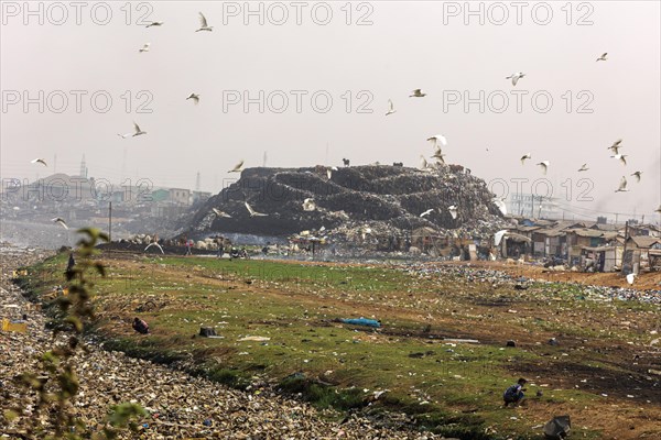 Textile dump in Accra, 21.02.2023. Wild rubbish dump of textile waste where several thousand people live, Accra, Ghana, Africa