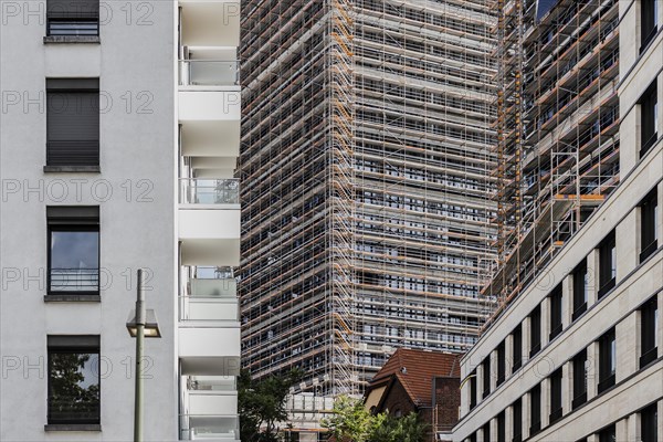 A scaffolded new building looms between two completed buildings in Berlin, 26.06.2022., Berlin, Germany, Europe