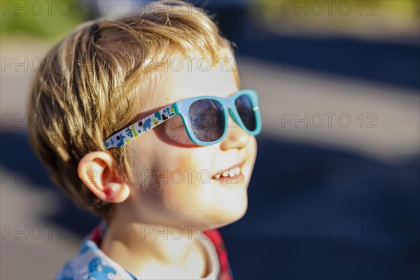 Toddler with sunglasses, enjoying autumn sunshine. Bonn, Germany, Europe