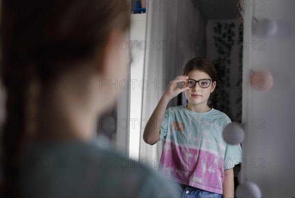 Ten year old girl betrays herself in the mirror, Bonn, Germany, Europe