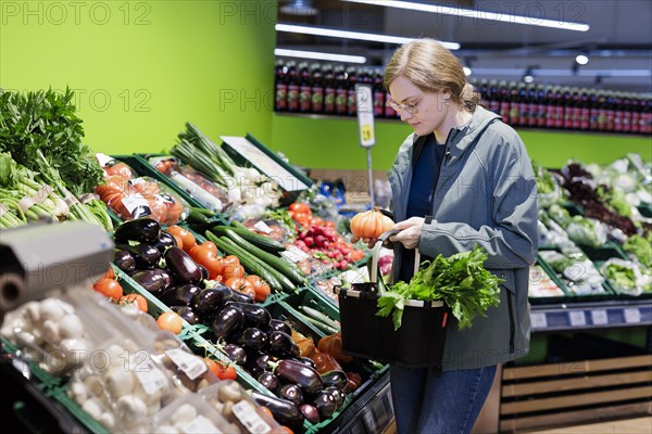 Young woman shopping in supermarket. Radevormwald, Germany, Europe