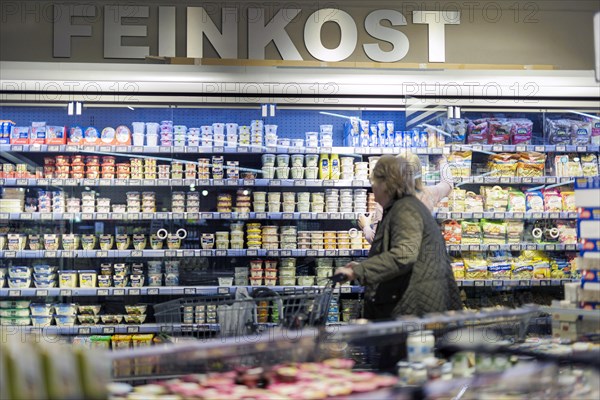 Elderly woman shopping in the delicatessen department at the supermarket, Radevormwald, Germany, Europe