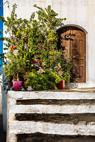 Old wooden doors with pebble mosaics on the floor, winding streets with white houses, Lindos, Rhodes, Greece, Europe