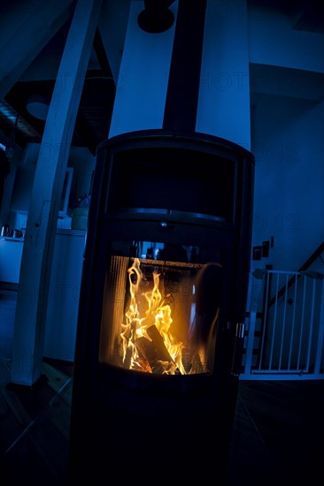 Symbolic photo: A fire burns in a stove in a flat. Berlin, 03.03.2023, Berlin, Germany, Europe