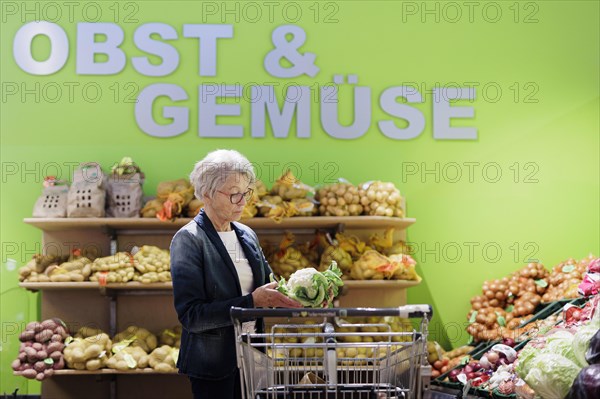 Older woman buys a cauliflower in the supermarket, Radevormwald, Germany, Europe