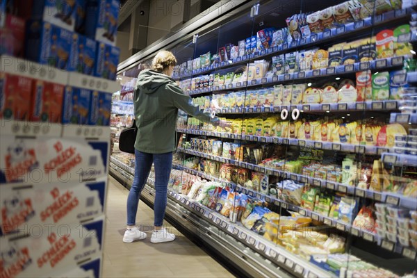 Young woman shopping in supermarket. Radevormwald, Germany, Europe