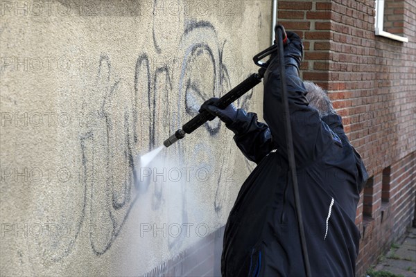 Removal of graffiti from house wall, high-pressure cleaner, residential area, Duesseldorf, North Rhine-Westphalia, Germany, Europe