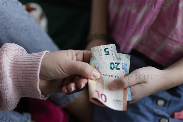 Childrens hand and banknotes, pocket money for a 10 year old, Bonn, Germany, Europe