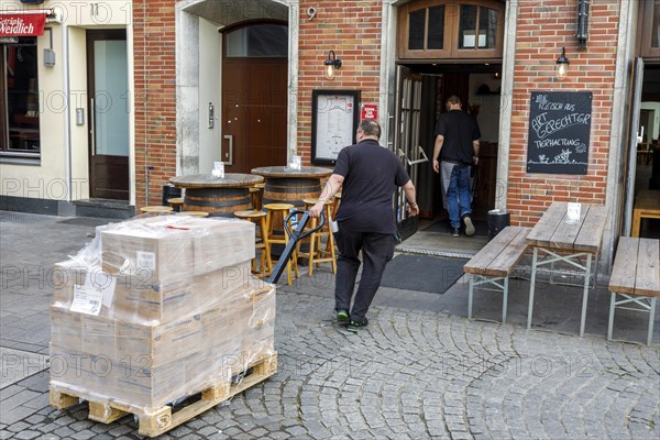 Delivery traffic in Duesseldorfs old town, transporting ordered goods to the customer using a pallet truck, gastronomy, wholesale, Duesseldorf, North Rhine-Westphalia, Germany, Europe