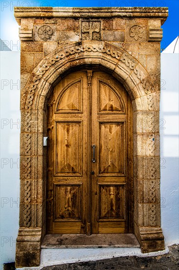 Old wooden doors with pebble mosaics on the floor, winding streets with white houses, Lindos, Rhodes, Greece, Europe