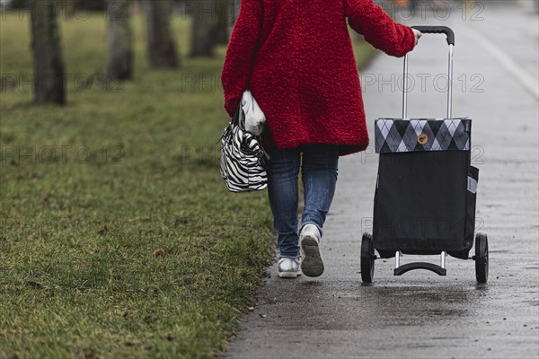 An elderly woman with a rolling bag, photographed in the Marzahn district of Berlin, 01.02.2023., Berlin, Germany, Europe