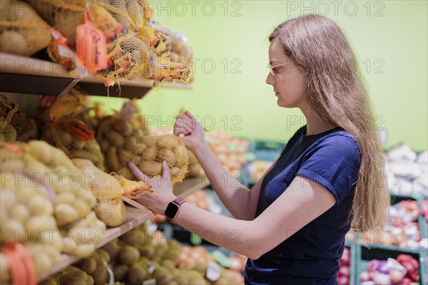 Younger woman shopping in supermarket, Radevormwald, Germany, Europe