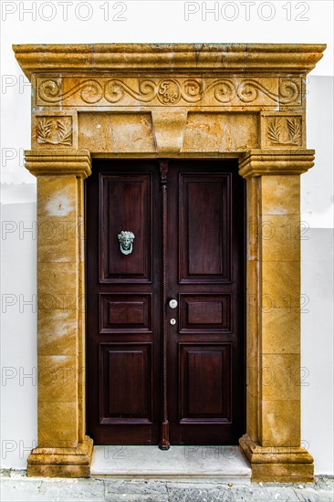 Old wooden doors with pebble mosaics on the floor, winding streets with white houses, Lindos, Rhodes, Greece, Europe