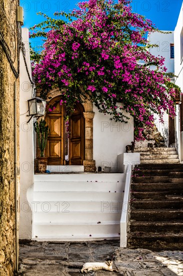 Old wooden doors with pebble mosaics on the floor, winding streets with white houses, Lindos, Rhodes, Greece, Europe