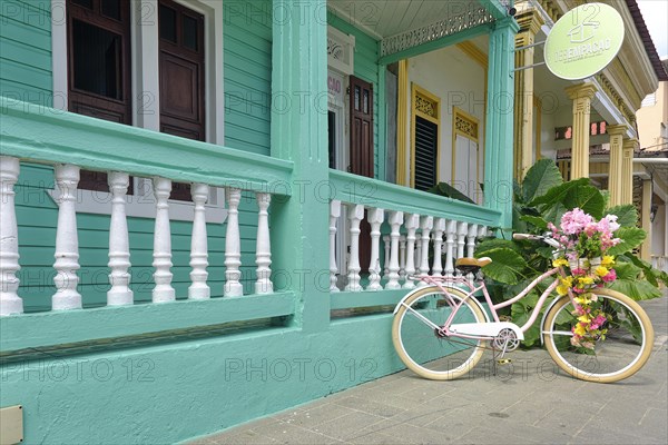 Bicycle with flowers in front of a colonial house in the Centro Historico, Old Town of Puerto Plata, Dominican Republic, Caribbean, Central America