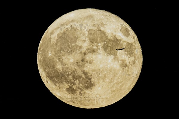 A plane looms in front of the so-called strawberry moon looms as it rises in Berlin, 14.06.2022., Berlin, Germany, Europe
