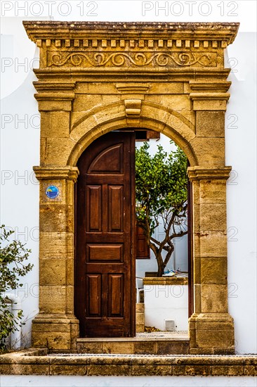 Old wooden doors with pebble mosaics on the floor, winding streets with white houses, Lindos, Rhodes, Greece, Europe