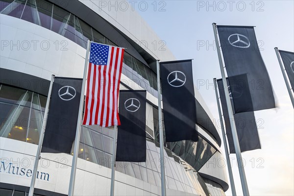 The American flag flies in front of the Mercedes Museum, Mercedes-Benz Group AG, Stuttgart, Baden-Wuerttemberg, Germany, Europe