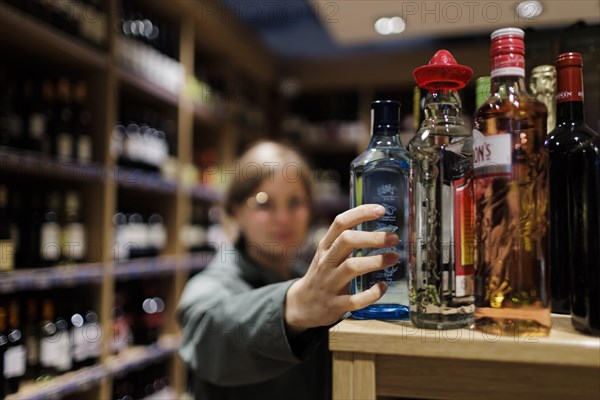 Young woman, buying alcoholic beverages at the supermarket. Radevormwald, Germany, Europe