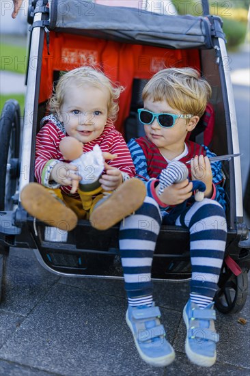 Siblings in a bicycle trailer. Bonn, Germany, Europe