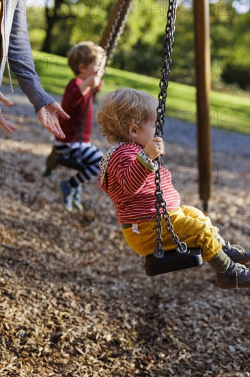 Children on a swing. Bonn, Germany, Europe