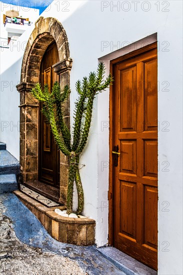 Old wooden doors with pebble mosaics on the floor, winding streets with white houses, Lindos, Rhodes, Greece, Europe