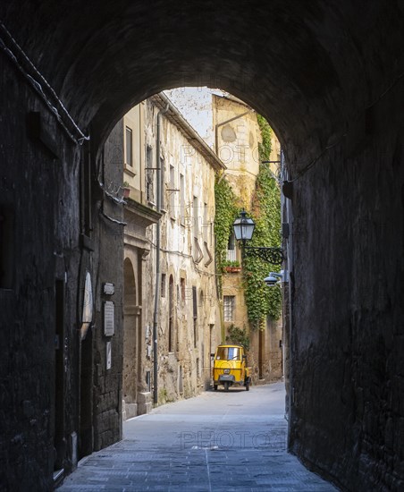 Three-wheeler in the streets of Pitigliano old town, Tuscany, Italy, Europe