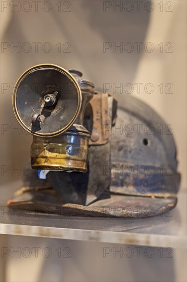 Beckley, West Virginia, A miners carbide lamp attached to his helmet on display at the mine museum at the Beckley Exhibition Coal Mine. In the lamp, calcium carbide reacts with water to produce acetylene, which burns with a strong flame