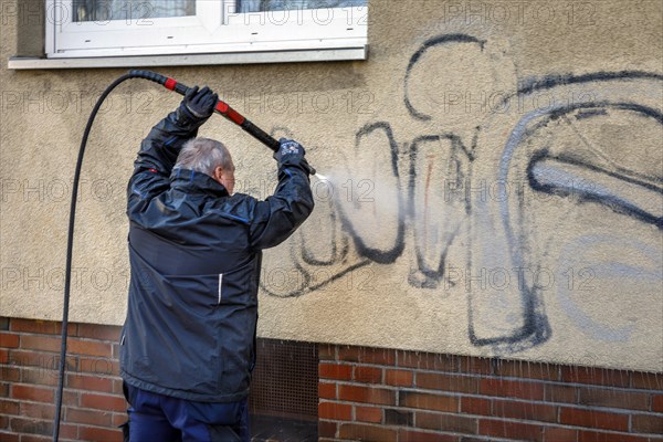 Removal of graffiti from house wall, high-pressure cleaner, residential area, Duesseldorf, North Rhine-Westphalia, Germany, Europe