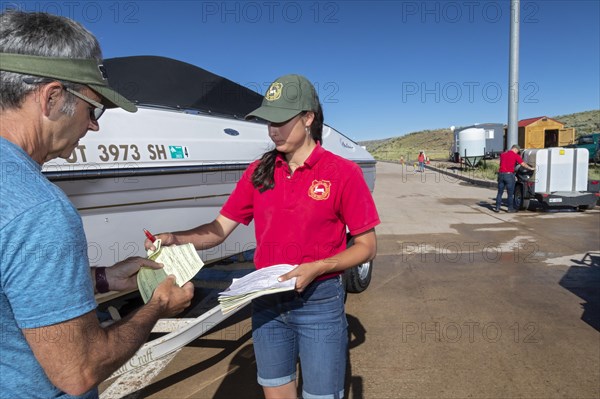Evanston, Wyoming, An employee of the Wyoming Game & Fish Department gives a boat owner a receipt after inspecting and decontaminating the watercraft at a mandatory inspection station along the Utah border. The intent is to keep invasive aquatic species, including zebra mussels and quagga mussels, out of the states waters