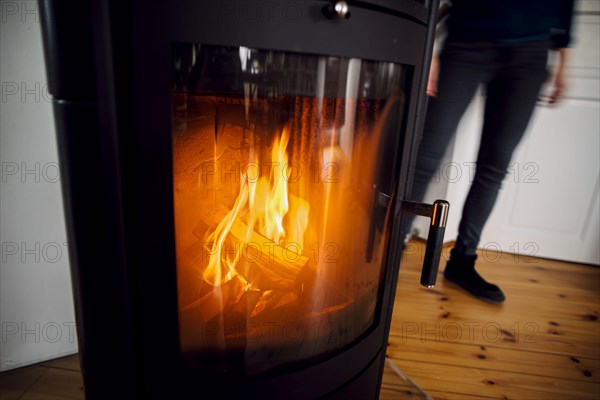 Symbolic photo: A fire burns in a stove in a flat. Berlin, 03.03.2023, Berlin, Germany, Europe