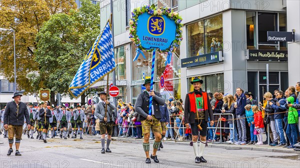 Festival procession, entry of the Wiesnwirte, Trachtler with flag and motif panel of the Loewenbraeufest tent, Oktoberfest, Munich, Upper Bavaria, Bavaria, Germany, Europe