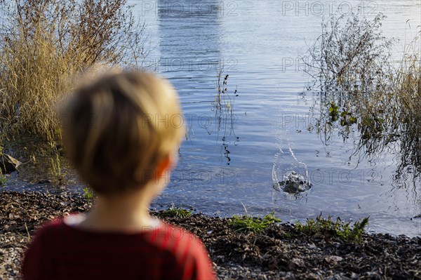 Child playing by a body of water. Bonn, Germany, Europe