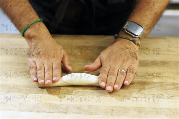 Rolling out a piece of dough., Bad Urach, Baden-Wuerttemberg, Germany, Europe