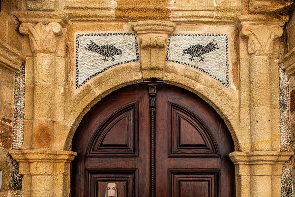 Old wooden doors with pebble mosaics on the floor, winding streets with white houses, Lindos, Rhodes, Greece, Europe