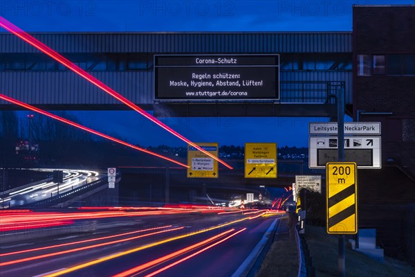 Vario display on the B10 B14 trunk road with information on corona protection, night photograph with light traces of vehicles, Stuttgart, Baden-Wuerttemberg, Germany, Europe