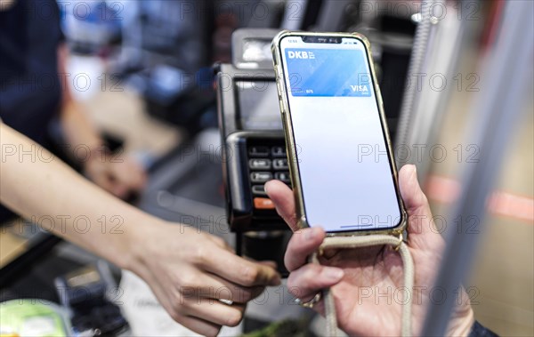 Payment by mobile phone in the supermarket. Radevormwald, Germany, Europe