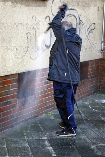 Removal of graffiti from house wall, high-pressure cleaner, residential area, Duesseldorf, North Rhine-Westphalia, Germany, Europe